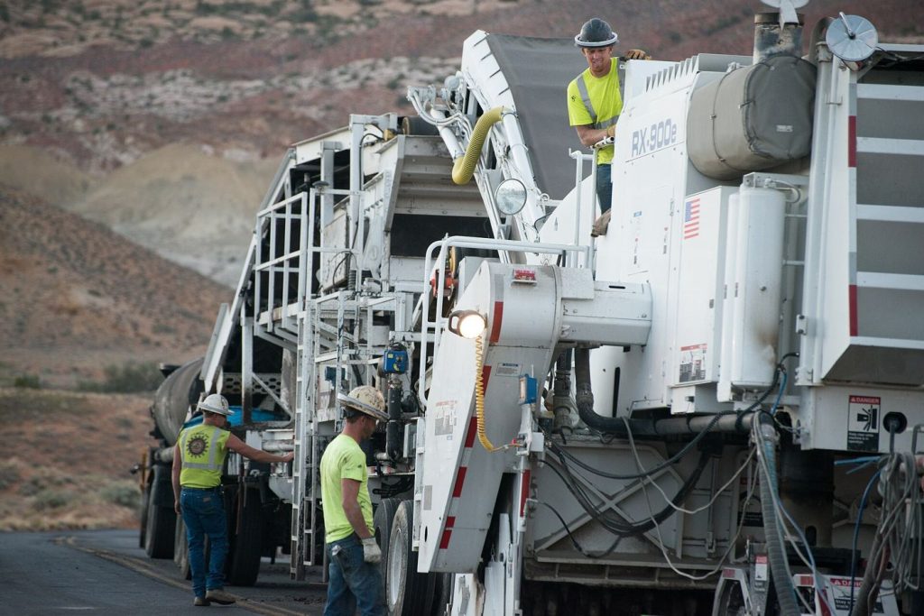 Overnight Resurfacing Keeps a Major Road Open by Day Road workers laying fresh asphalt during a road resurfacing project with machinery nearby.