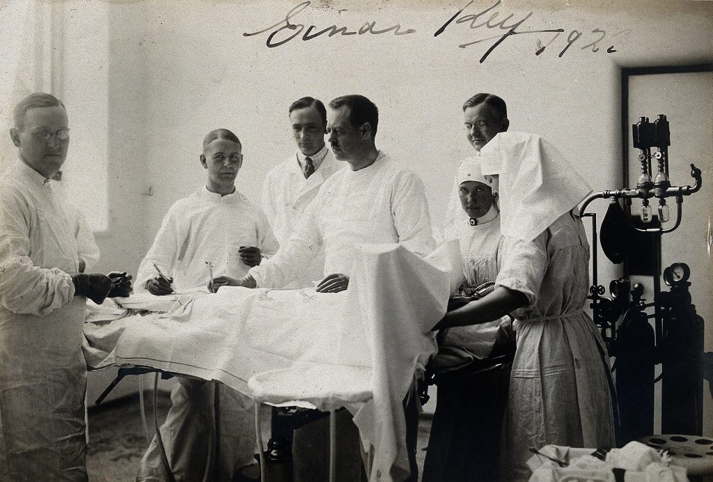 A surgical team at work in a modern operating theatre under bright lights.